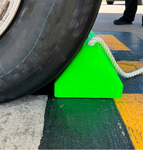 High-visibility green wheel chock ensuring vehicle safety